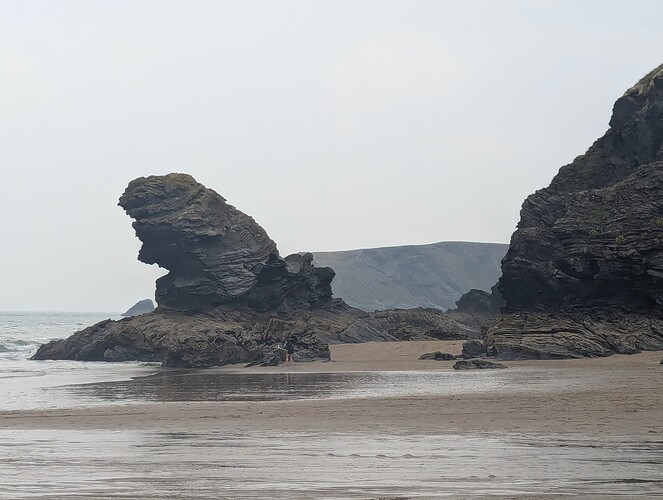 High quality image of a group of rocks on a beach along with a cliff