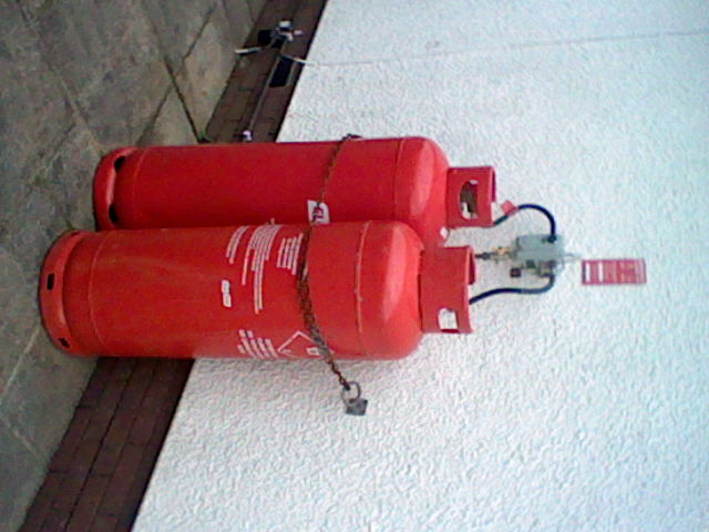 Low quality image of two gas canisters against a white wall