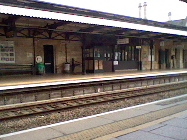 Train tracks and signs pointing out the exit and platform number